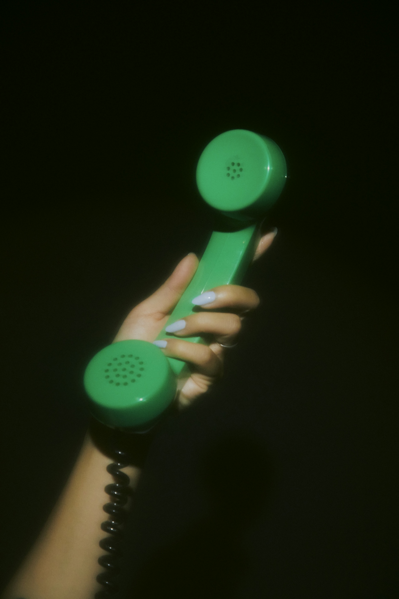 A photo of a hand holding a green phone against a black background used as the promotional photo for a blog post from Cool Copy Club about why brand messaging strategy is important for personal brands.